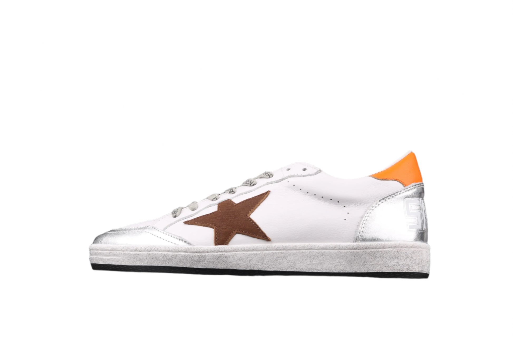 White sneaker with brown and orange accents on a black background