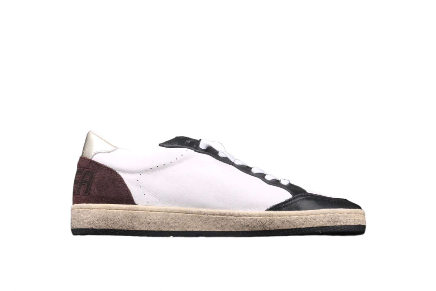 White sneaker with brown and black accents on a black background