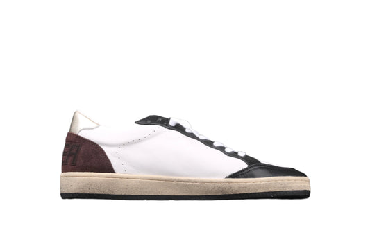 White sneaker with brown and black accents on a black background