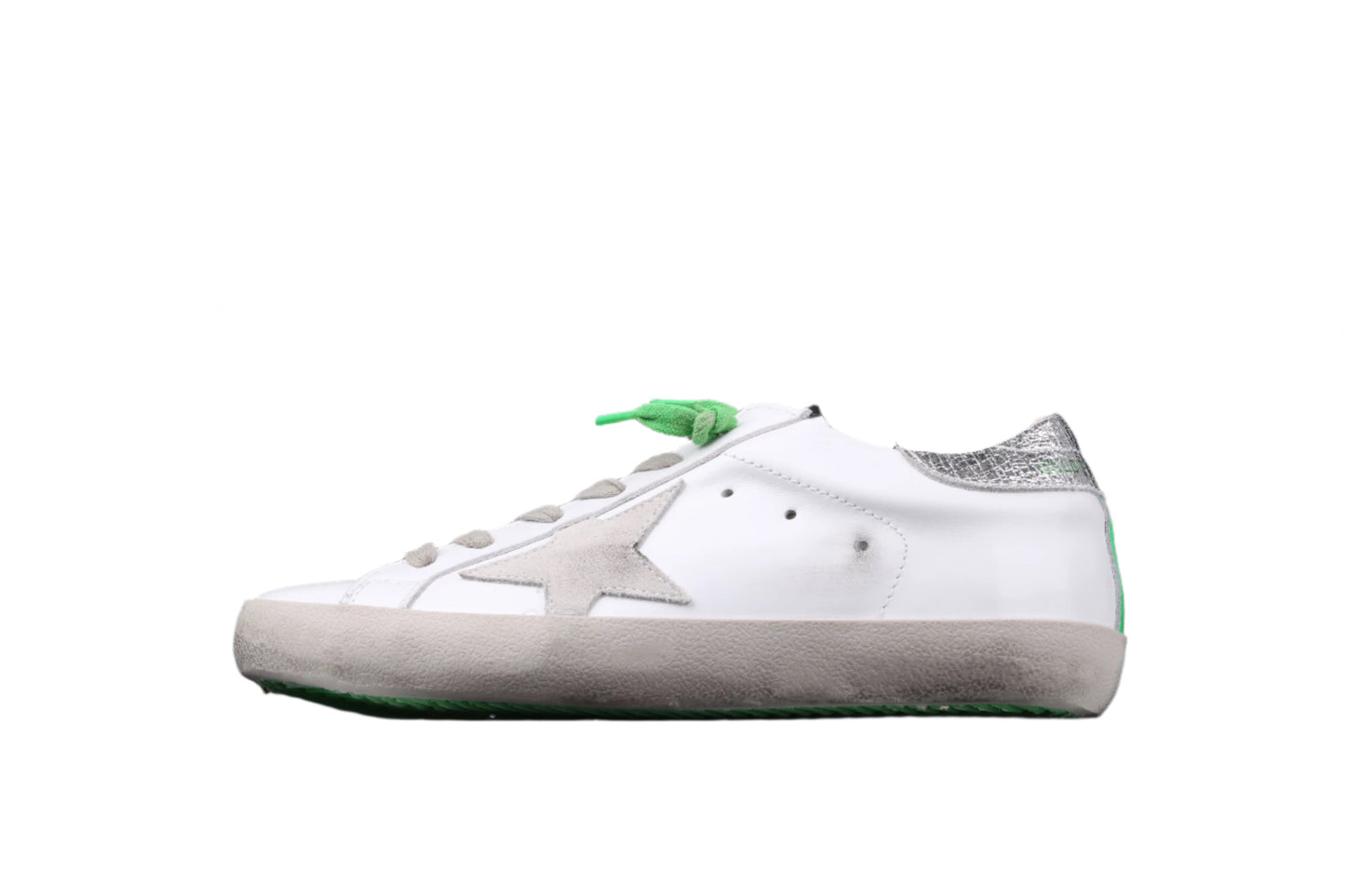 White sneaker with a green tag on a black background