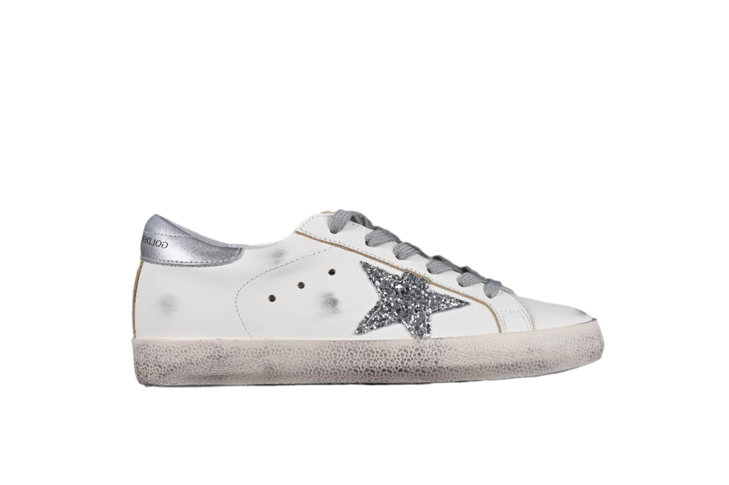 White sneaker with a silver star on a black background