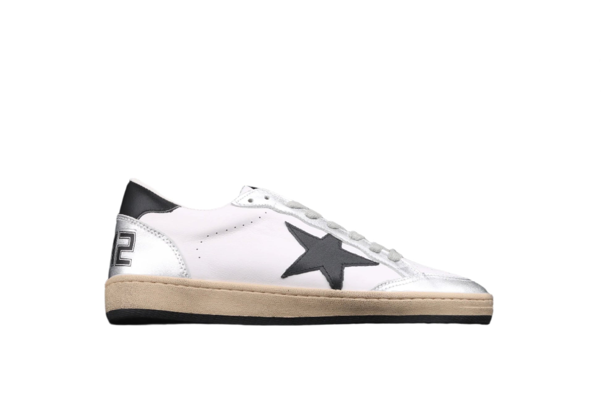 White sneaker with black star design on a black background
